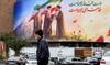A man walks near a banner displayed at Valiasr Square in central Tehran on March 10, 2026.