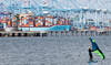 A person rides a wing foil near a container ship at the Port of Los Angeles on May 28, 2026 in Los Angeles, California. (AFP)