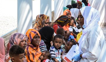 A nurse registers women with children waiting in the shade to receive medical care outside the Italian Paediatric Hospital.