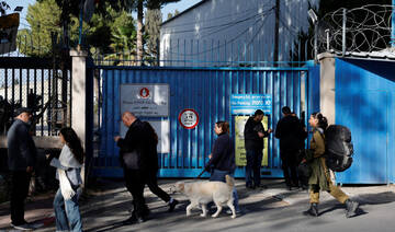 People walk outside the United Nations Relief and Works Agency for Palestine Refugees (UNRWA) headquarters, in Jerusalem.