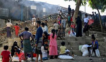 Rohingya refugees wait outside a distribution centre after collecting relief materials at the Kutupalong refugee camp.