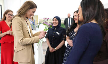 Britain's Catherine, Princess of Wales, reacts as she receives a gift during a visit.
