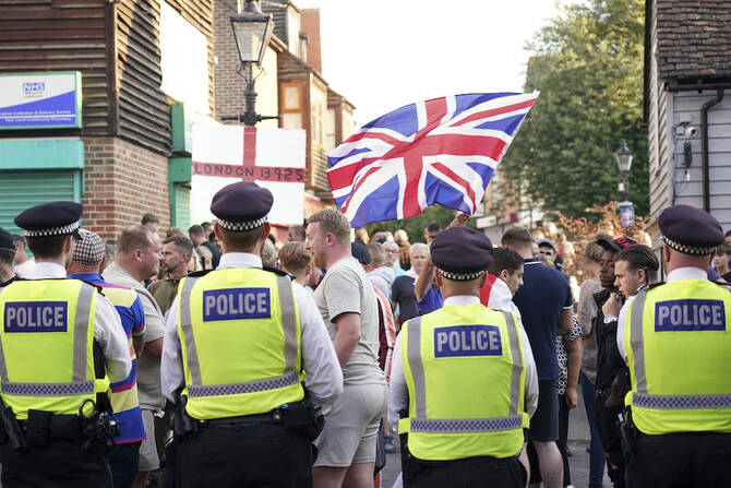 Protesters wave a Union Flag during an anti-migration demonstration in Orpington near London. (AP)